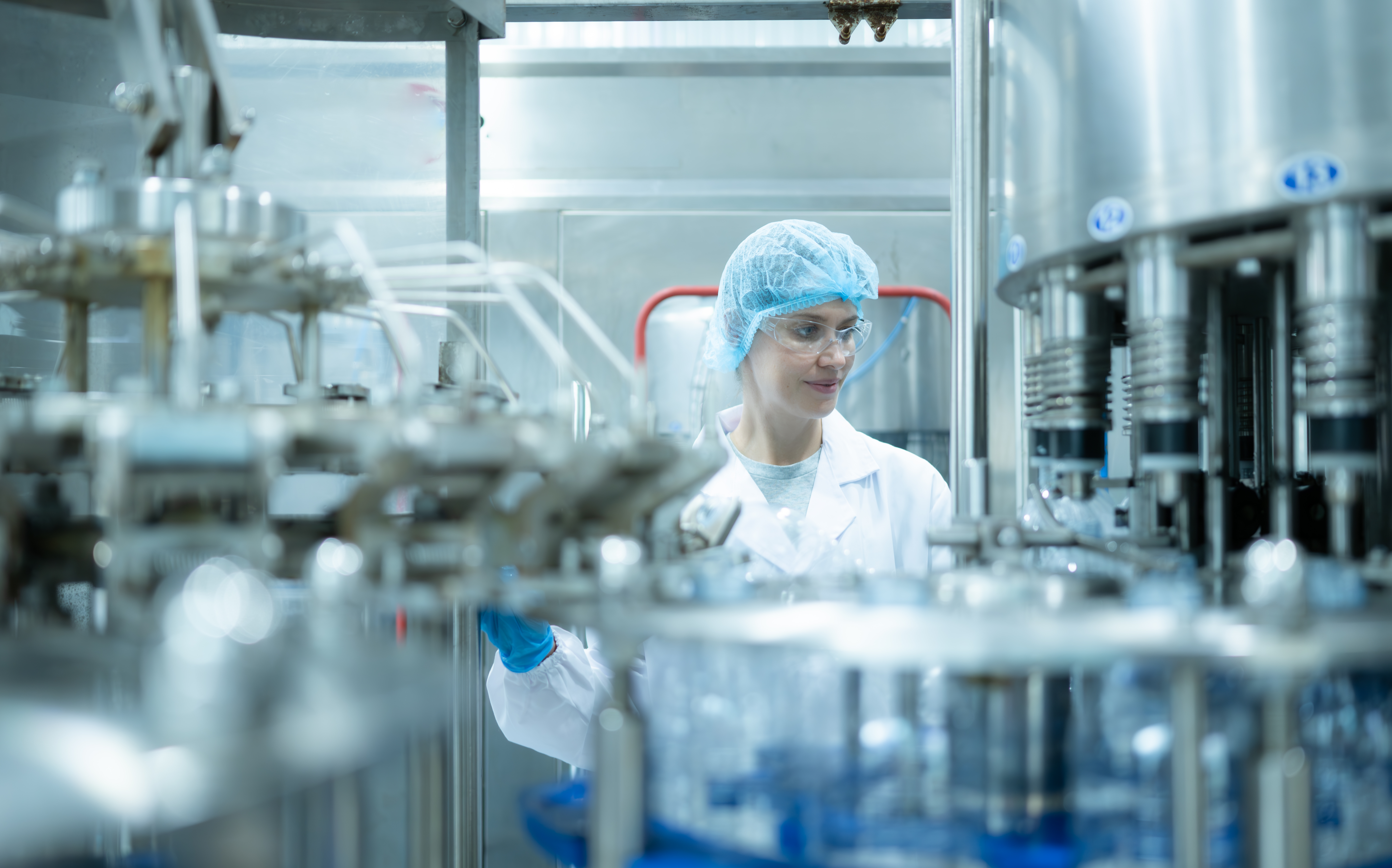 Female quality control worker inspecting water bottle on product